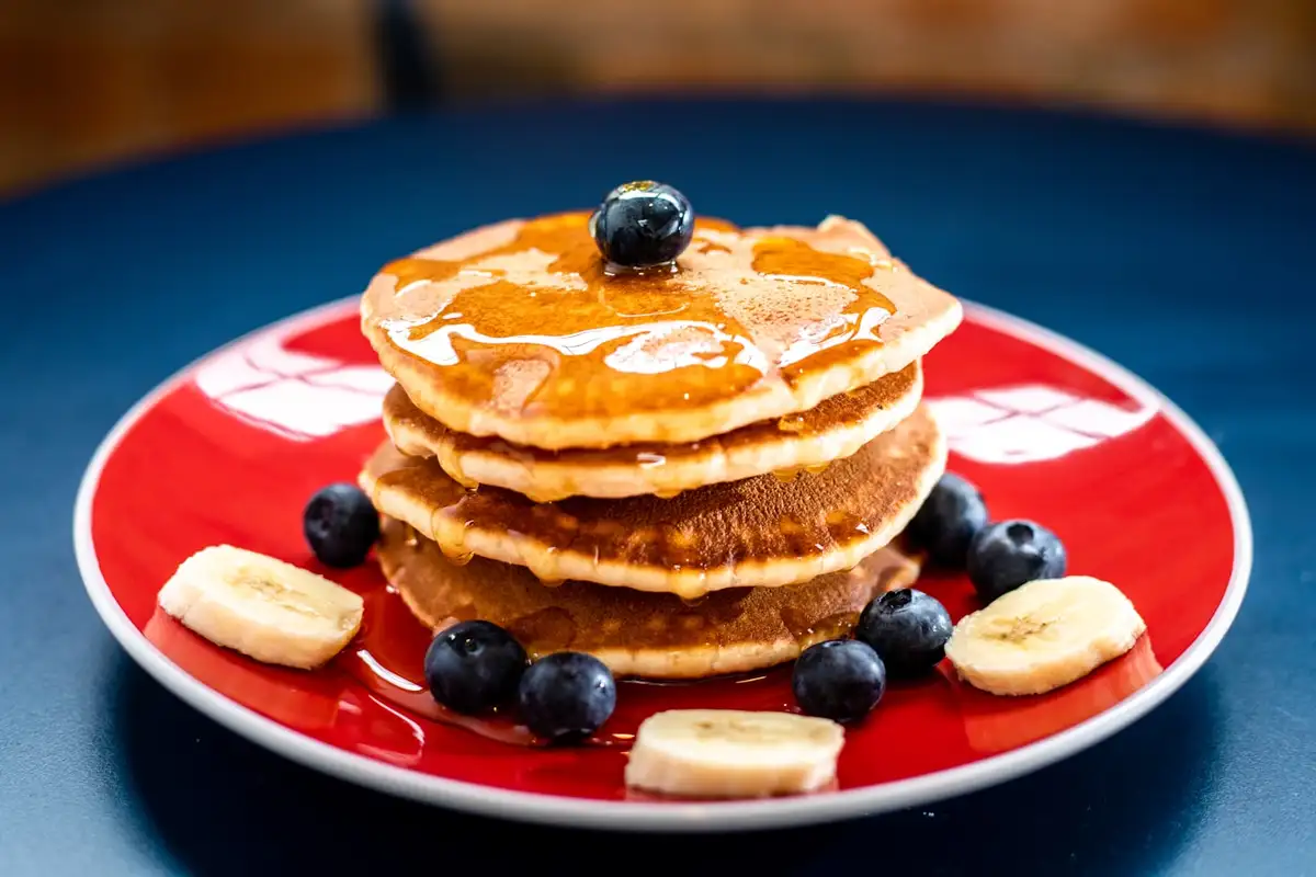 Stack of banana oat pancakes with fruit