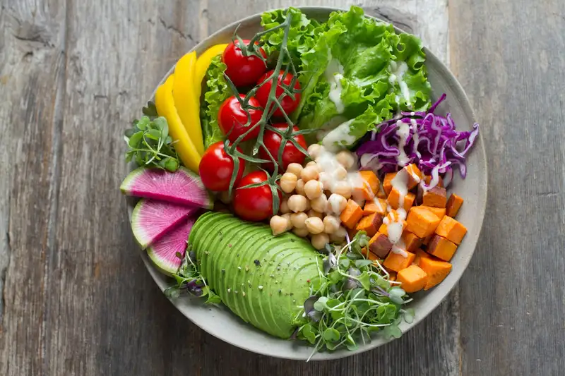 Colourful bowl with roasted sweet potato, chickpeas, and greens